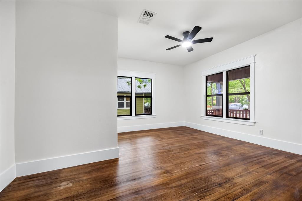 1014 Bolivar Street Denton, TX 76201 - Photo 27 of 36 an empty room with wooden floor ceiling fan and windows