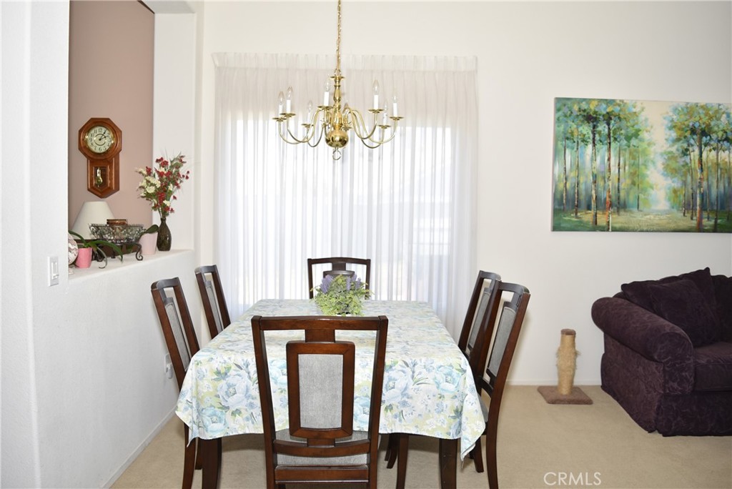 1665 Ravenswood Road Beaumont, CA 92223 - Photo 6 of 41 a view of a dining room with furniture wooden floor and a chandelier
