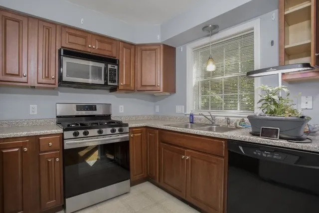 a kitchen with stainless steel appliances granite countertop a sink stove and microwave