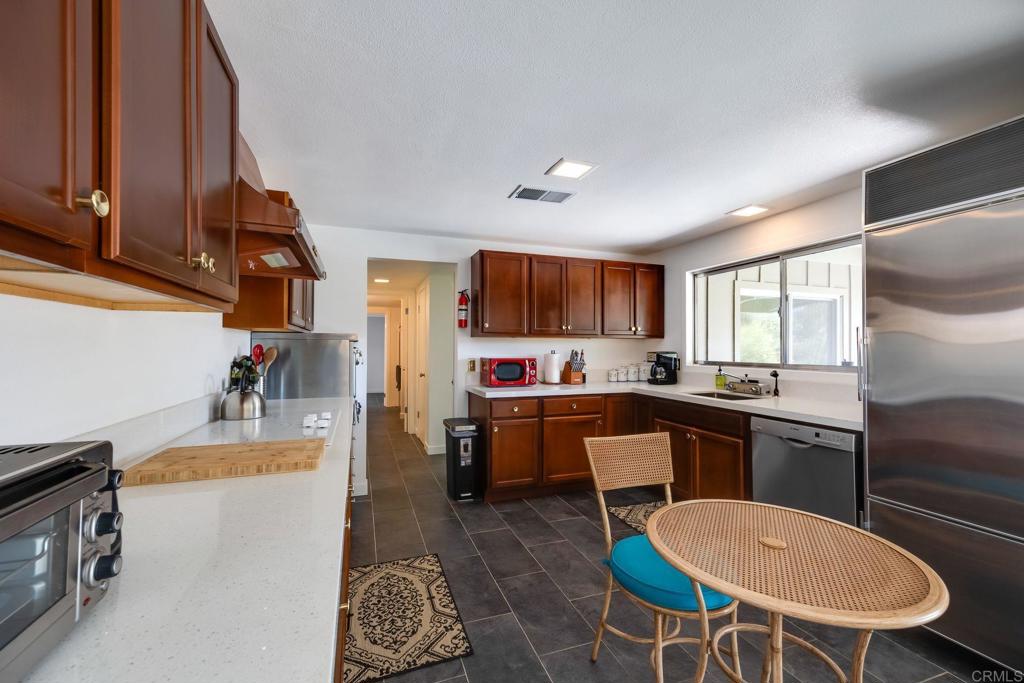 255 Montezuma Road Borrego Springs, CA 92004 - Photo 7 of 26 a kitchen with a table chairs microwave and cabinets