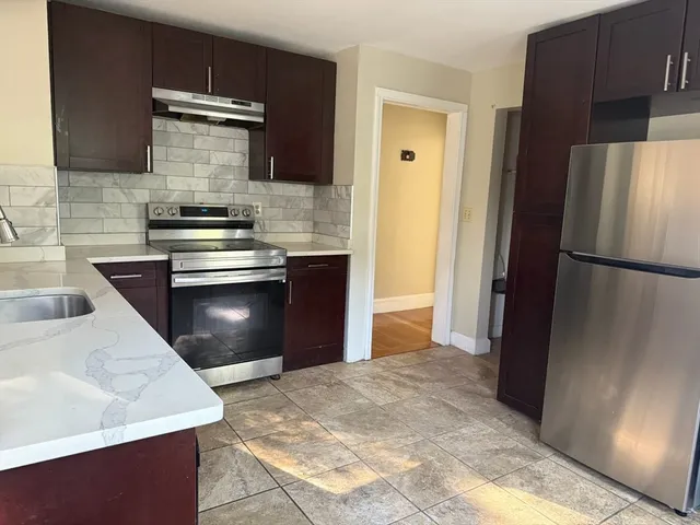 a kitchen with stainless steel appliances granite countertop a refrigerator and a sink
