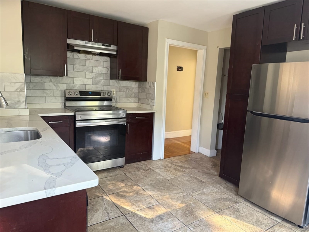 a kitchen with stainless steel appliances granite countertop a refrigerator and a sink
