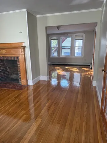 wooden floor in an empty room with a fireplace
