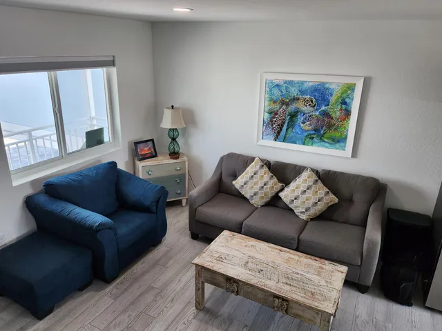 a living room with furniture and a painting on the wall