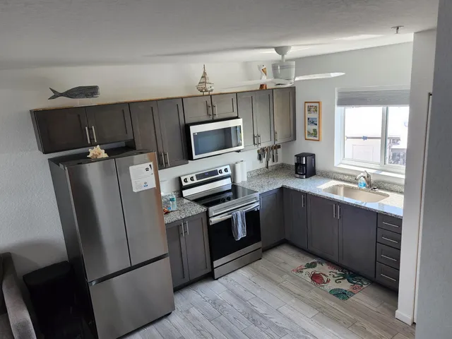 a kitchen with stainless steel appliances a refrigerator sink and microwave