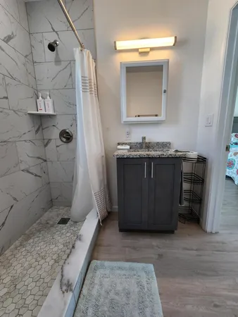 a bathroom with a granite countertop sink toilet and shower