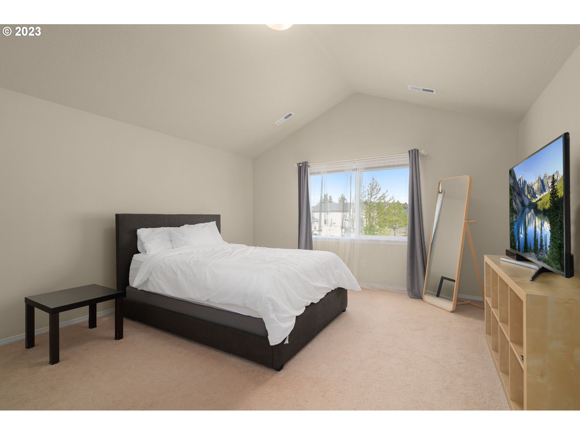 17697 Southwest September Lane Beaverton, OR 97003 - Photo 17 of 24 a spacious bedroom with a bed and a flat screen tv