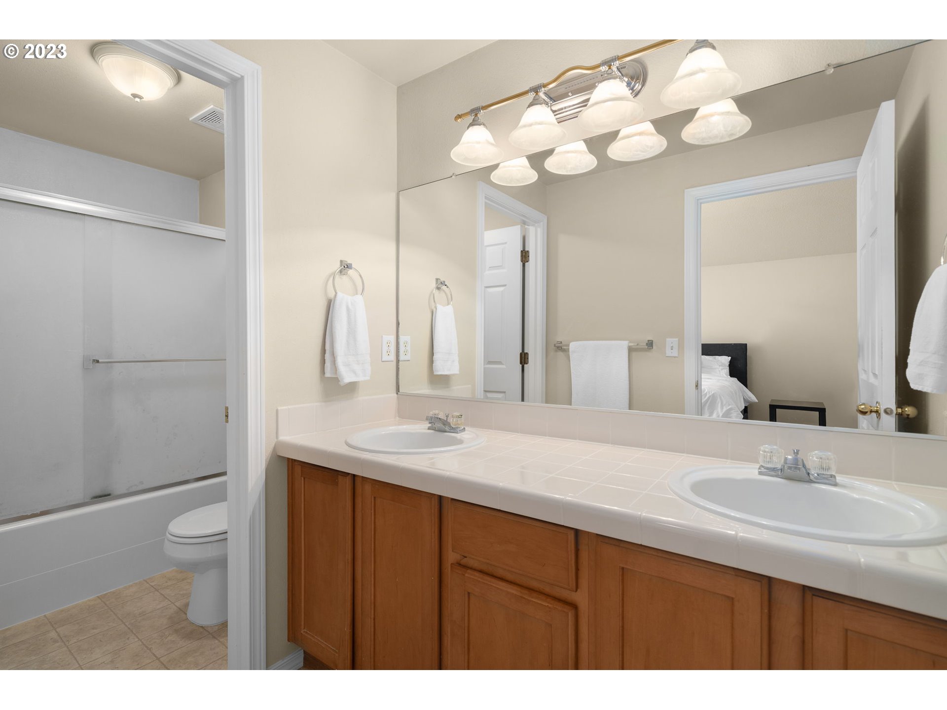 17697 Southwest September Lane Beaverton, OR 97003 - Photo 18 of 24 a bathroom with a sink a toilet and a large mirror