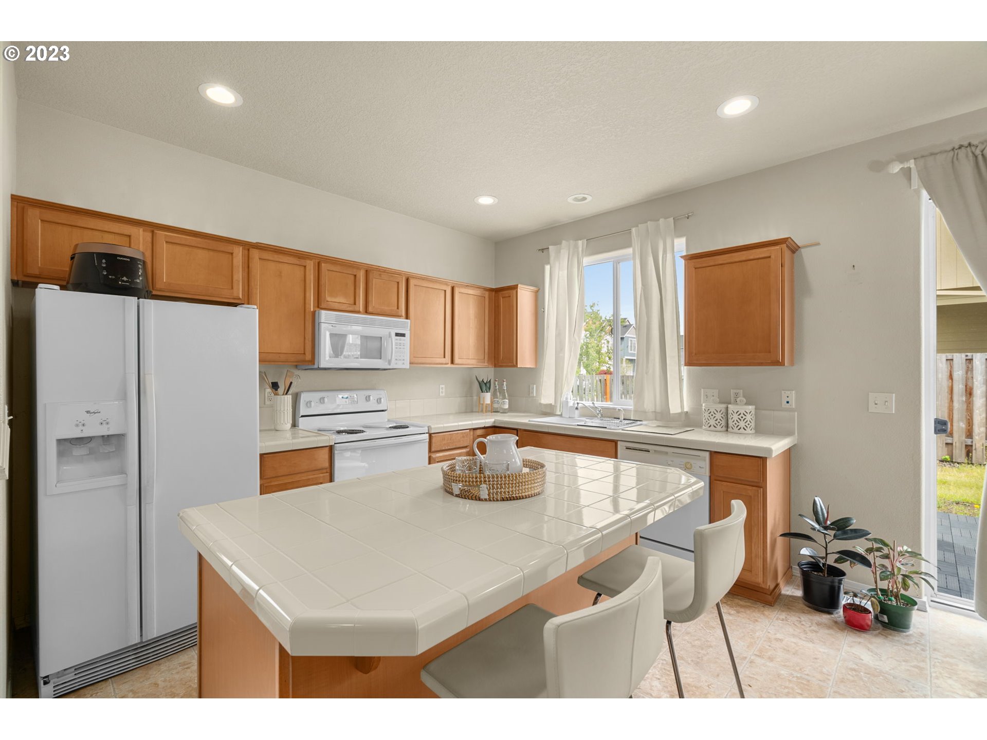 17697 Southwest September Lane Beaverton, OR 97003 - Photo 9 of 24 a kitchen with a refrigerator a sink dishwasher with a dining table and chairs