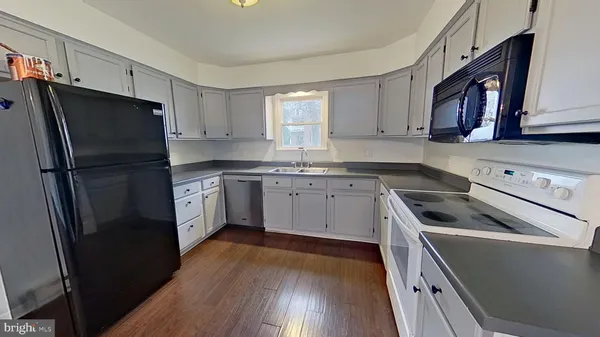 a kitchen with a refrigerator sink and cabinets