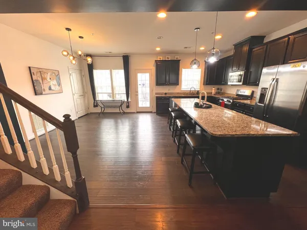 a large kitchen with sink a refrigerator and a view of living room