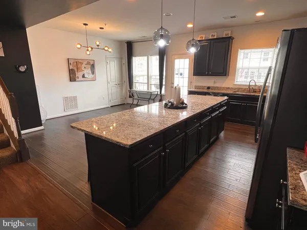 a kitchen with kitchen island granite countertop a sink appliances and cabinets