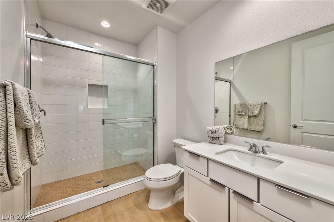 3327 Esker Rdg Avenue Henderson, NV 89044 - Photo 19 of 24 A well-lit primary bathroom featuring a spacious shower with glass enclosure and a single vanity.