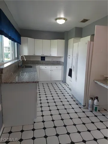 a kitchen with a sink a refrigerator and a stove top oven