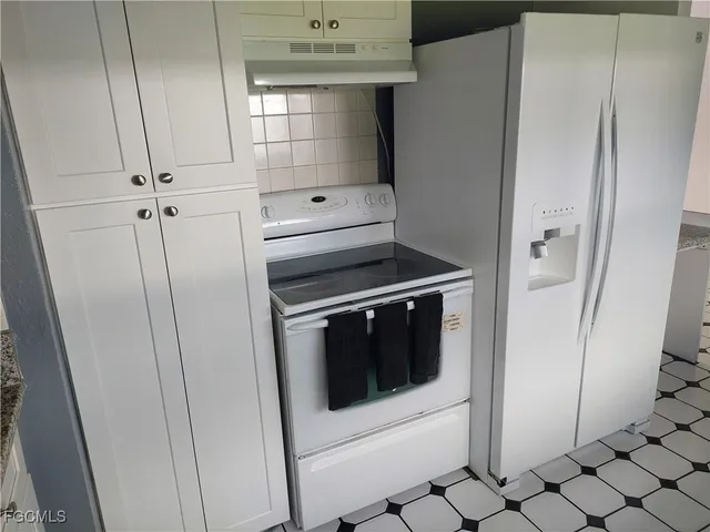 a kitchen with white cabinets and white appliances