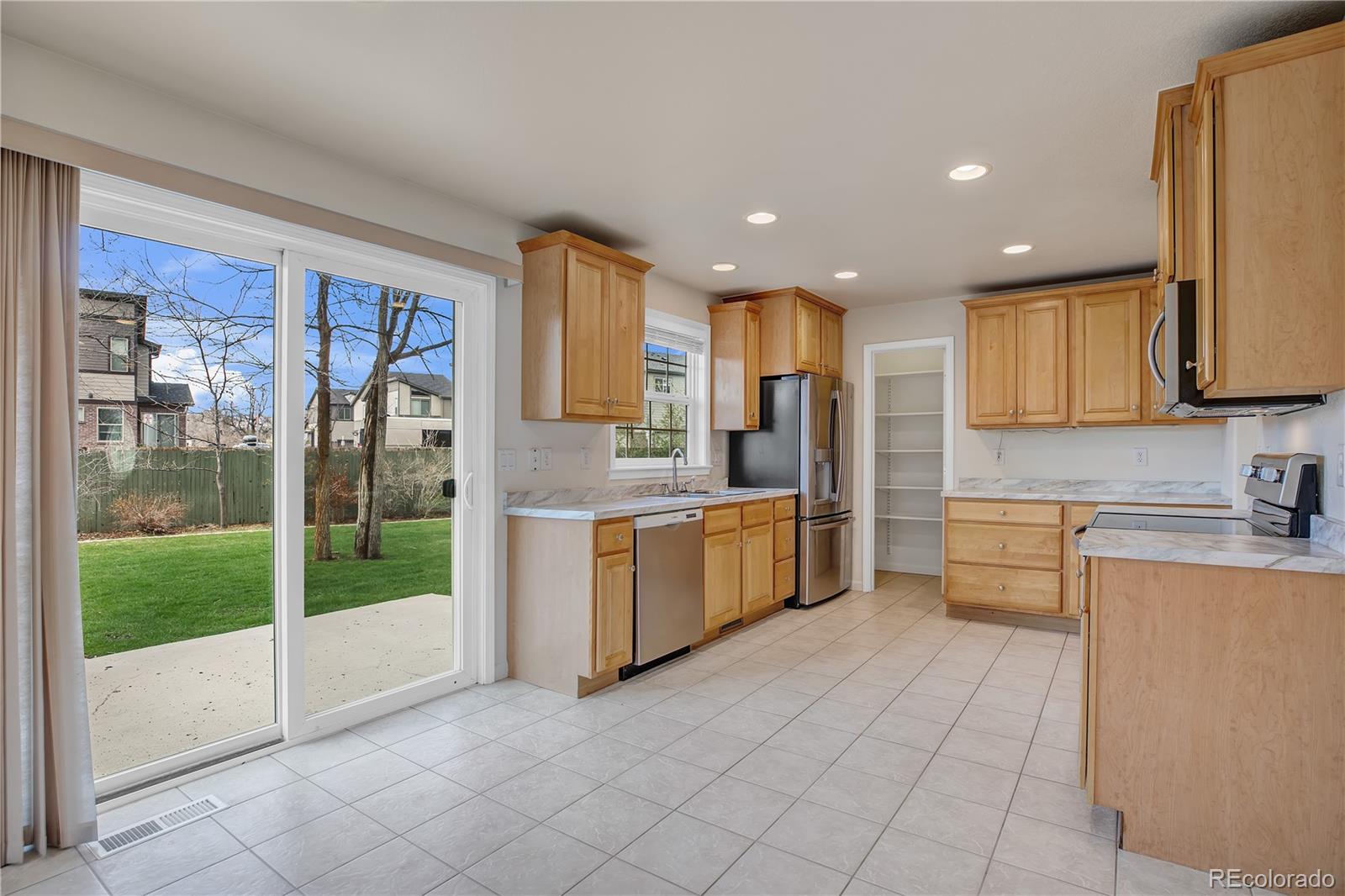 4505 Simms Court Wheat Ridge, CO 80033 - Photo 14 of 37 a large kitchen with a large window and a refrigerator