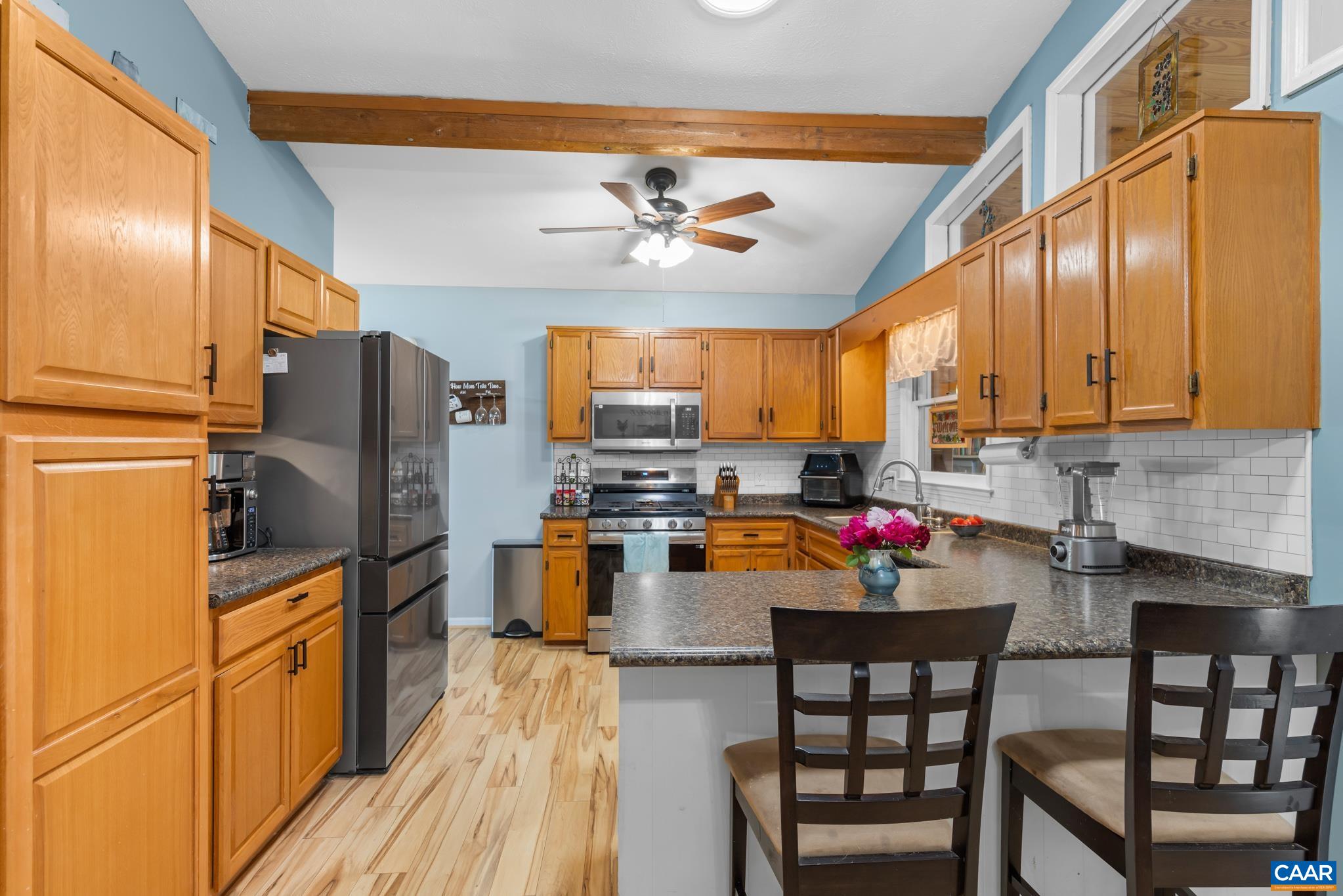 1971 Wilderness Road Reva, VA 22735 - Photo 12 of 47 a open kitchen with stainless steel appliances granite countertop a refrigerator a stove top oven a sink dishwasher and dining table with wooden floor