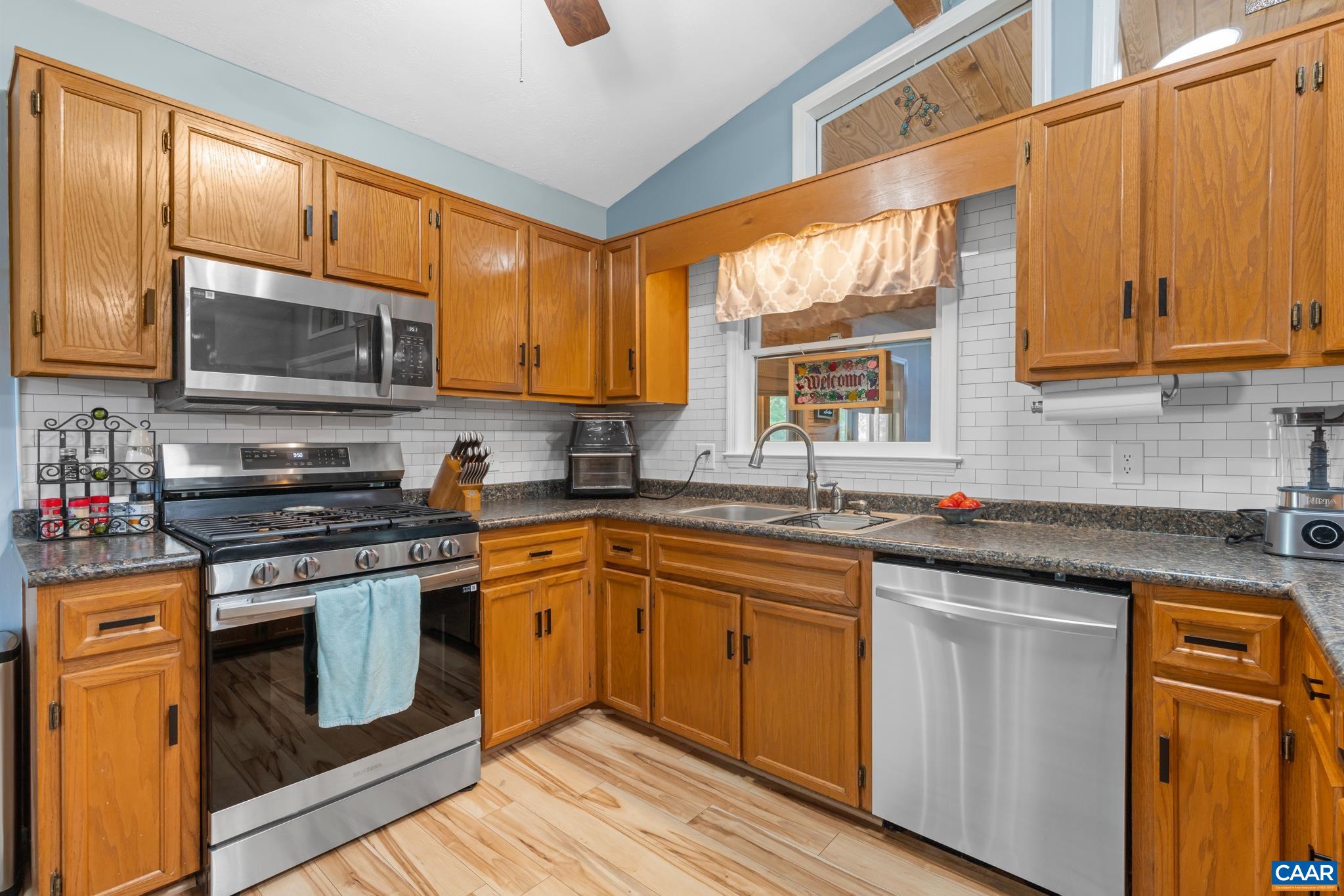 1971 Wilderness Road Reva, VA 22735 - Photo 10 of 47 a kitchen with stainless steel appliances granite countertop wooden cabinets stove top oven and sink