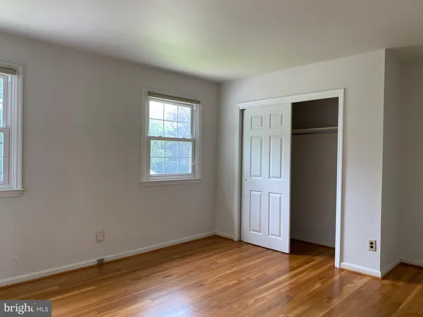 an empty room with wooden floor and closet
