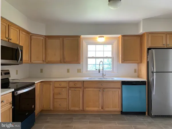 a kitchen with stainless steel appliances granite countertop a sink a stove a refrigerator a microwave and cabinets