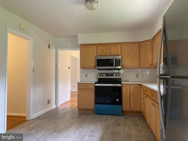 a kitchen with wooden cabinets and stainless steel appliances