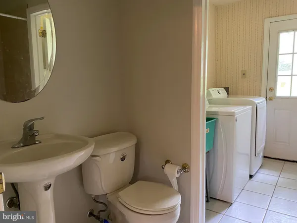 a bathroom with a toilet a sink and mirror