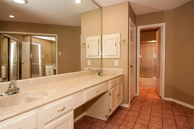 a spacious bathroom with a shower a sink and a mirror