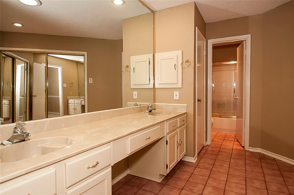 1004 Ledgemont Drive Plano, TX 75025 - Photo 19 of 29 a spacious bathroom with a shower a sink and a mirror