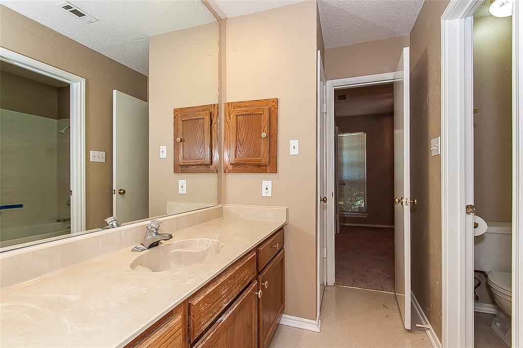 1004 Ledgemont Drive Plano, TX 75025 - Photo 24 of 29 a en suite bathroom with a double vanity sink a mirror and a shower
