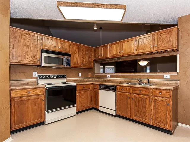 a kitchen with stainless steel appliances wooden cabinets and a sink
