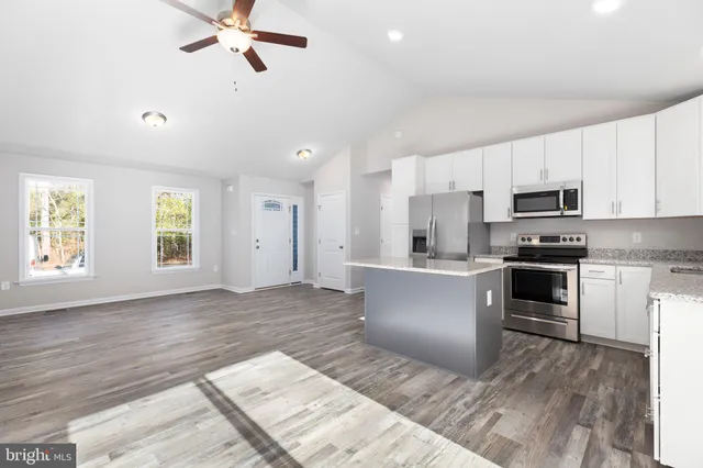 a kitchen with a refrigerator and white cabinets