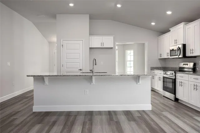 a view of a kitchen with wooden floor and a window