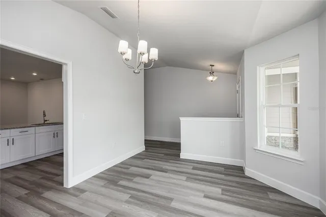 a view of a room with wooden floor and chandelier