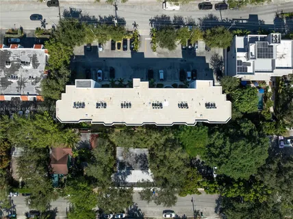 an aerial view of a house with a yard and large trees