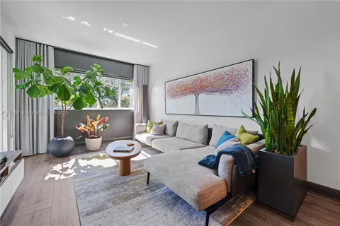 a living room with furniture potted plant and a window