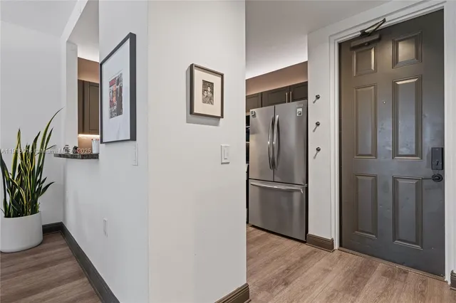 a view of a hallway with wooden floor and a potted plant