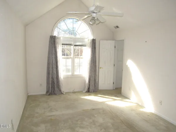 an empty room with a window and a chandelier