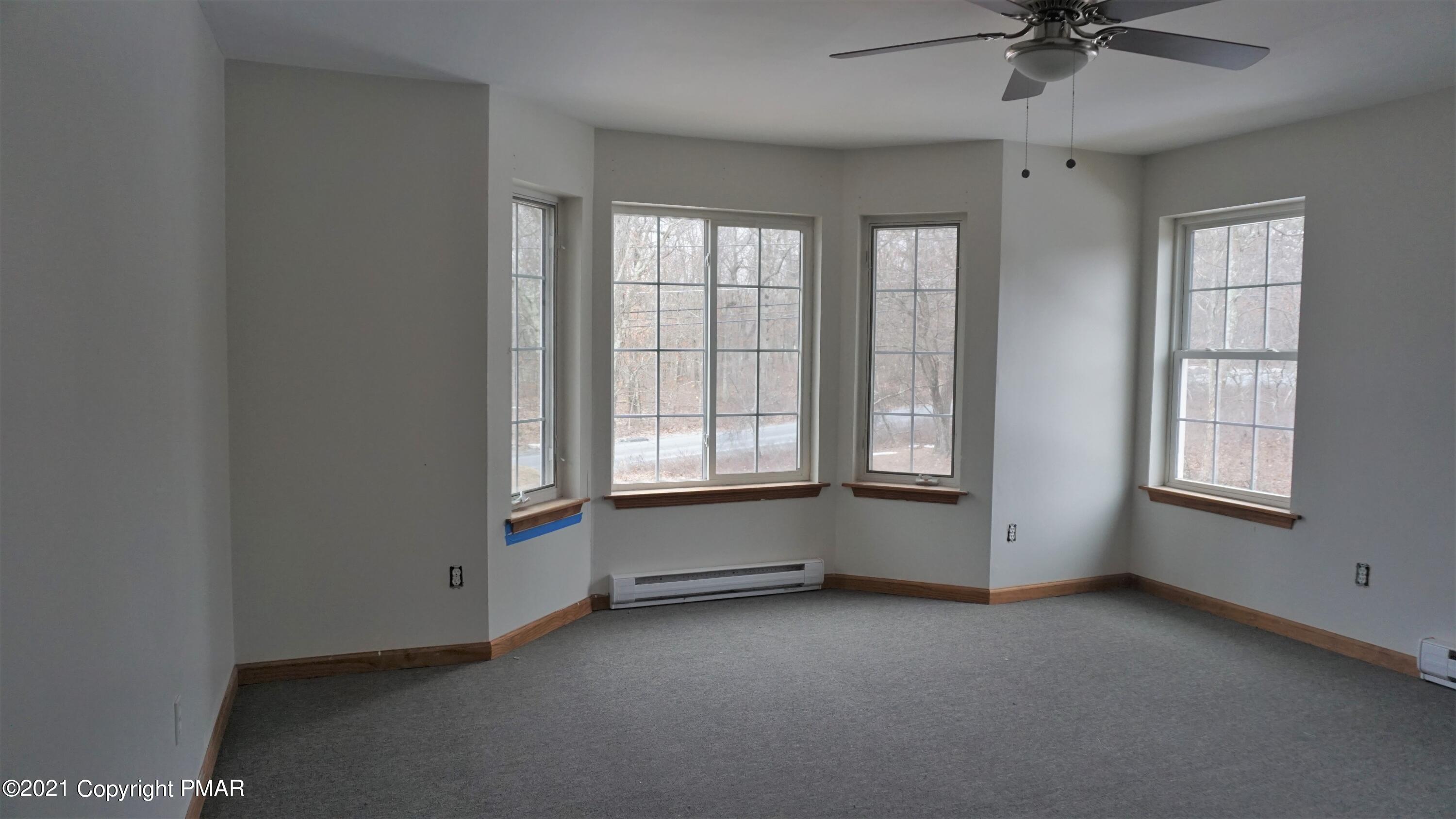 398 Gold Finch Road Bushkill, PA 18324 - Photo 11 of 24 an empty room with chandelier fan and windows