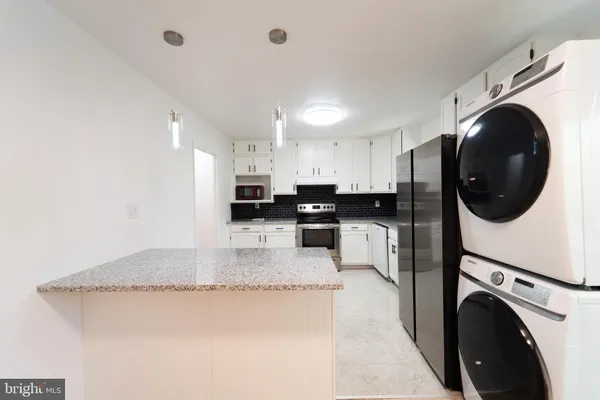 a kitchen with granite countertop white cabinets stainless steel appliances and a sink