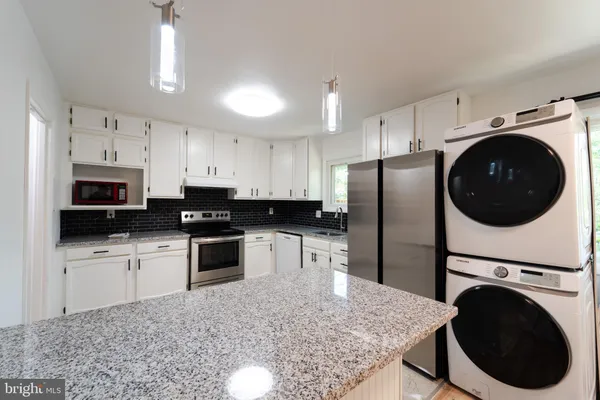 a kitchen with white cabinets and white appliances