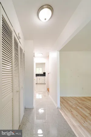 a view of a hallway with wooden floor and a living room