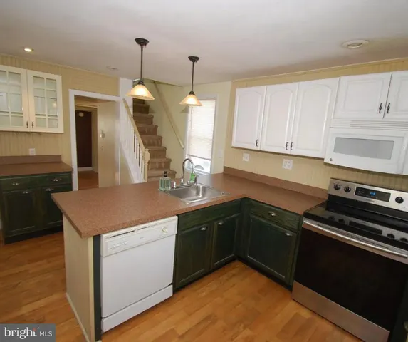 a kitchen with a sink a stove and cabinets