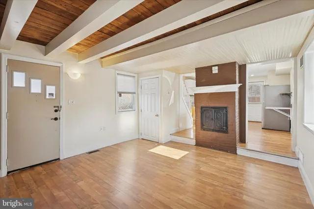 a view of a livingroom with wooden floor and a fireplace