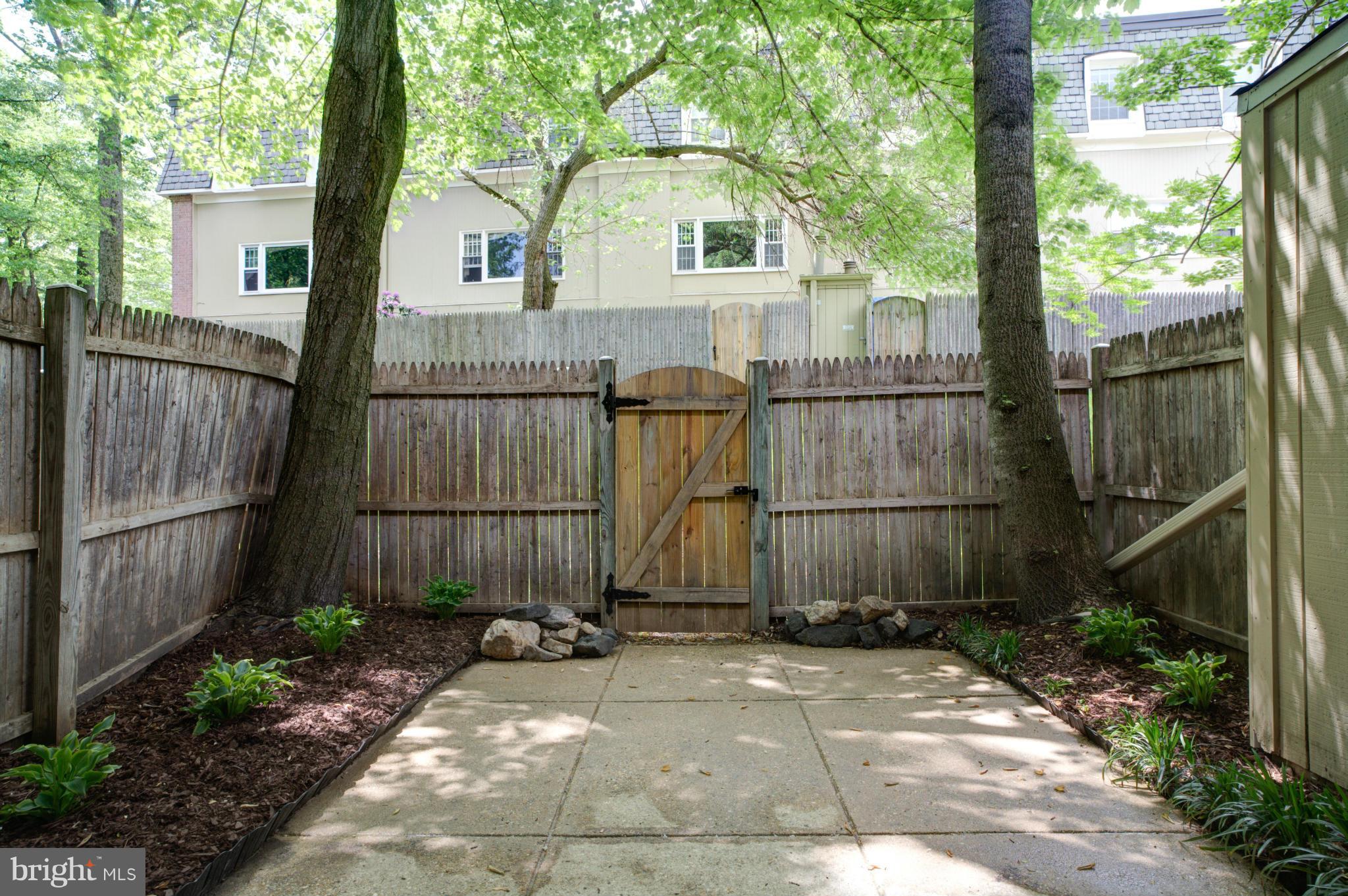 8129 Kingsway Court, Unit 283 Springfield, VA 22152 - Photo 18 of 22 a view of a white house with a small yard and wooden fence