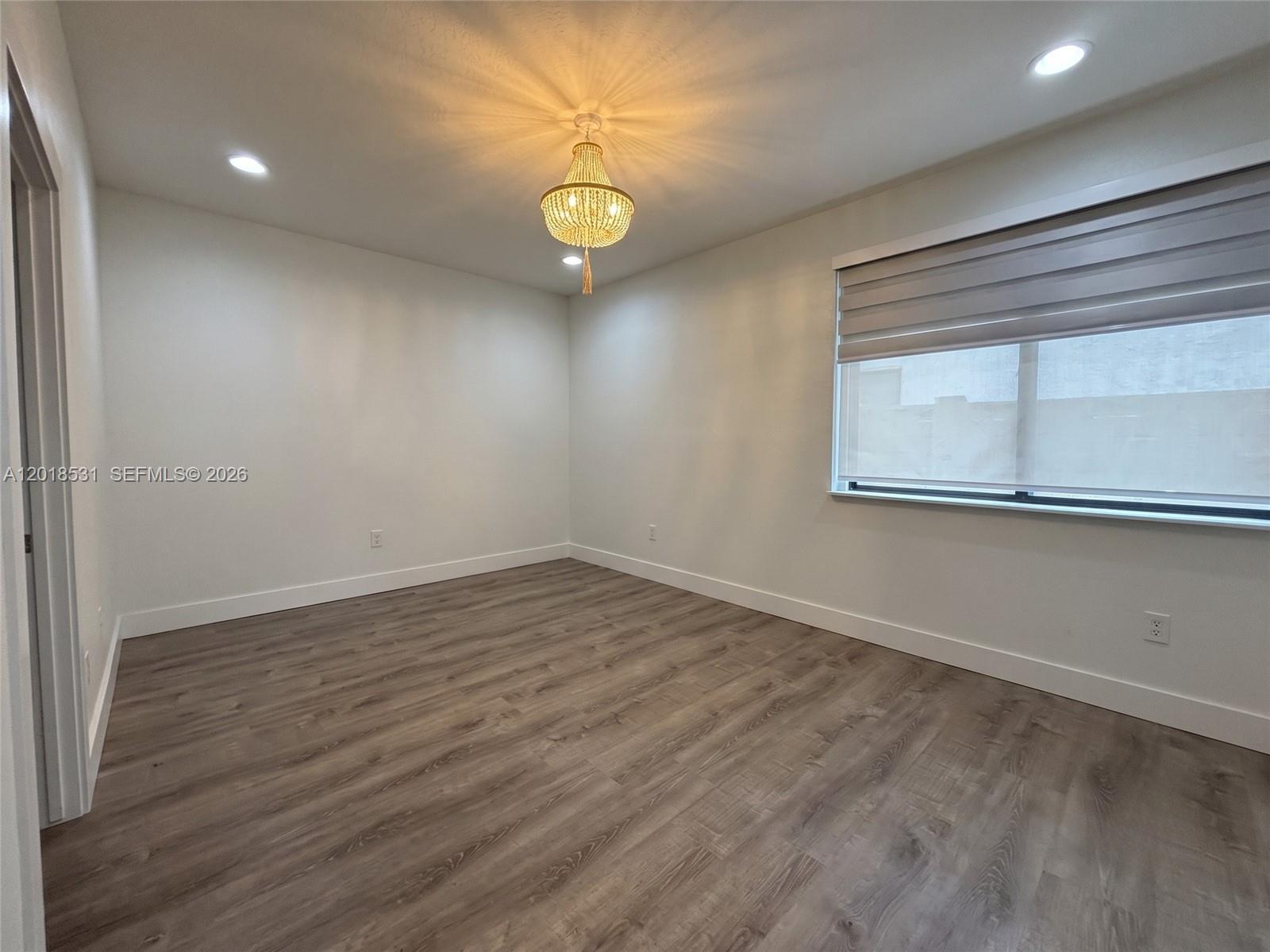 1575 Southeast 20th Road Homestead, FL 33035 - Photo 9 of 19 an empty room with wooden floor and windows