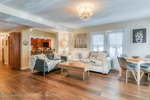 a living room with furniture a dining table and a chandelier