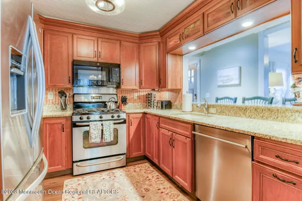 a kitchen with stainless steel appliances granite countertop a stove and a sink