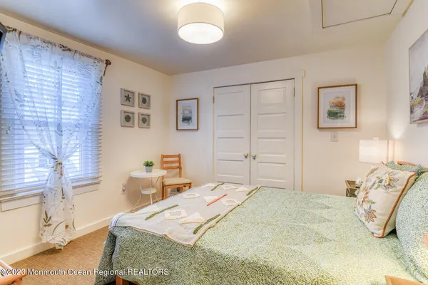 a bed sitting in a bedroom next to a window with a flat screen tv