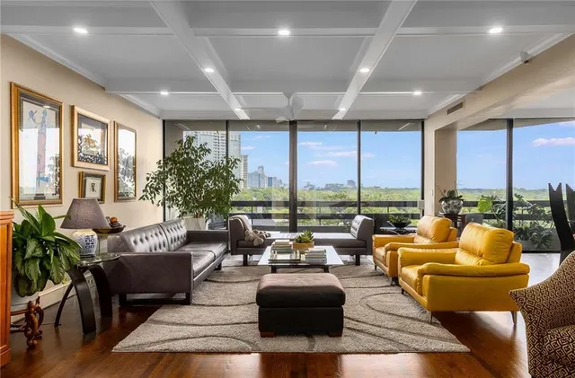 a living room with furniture and floor to ceiling windows
