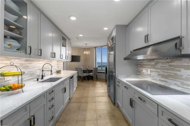 a large kitchen with stainless steel appliances lots of counter space and a sink